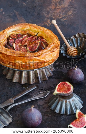Cake with figs and honey of flaky pastry, on a dark background. selective focus