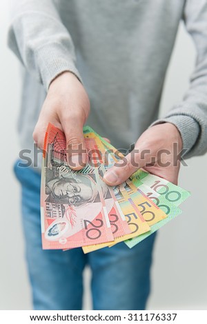 Human hand with Australian money giving some money.