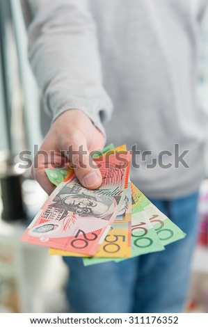 Human hand with Australian money giving some money