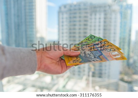 Human hand with Australian money with business building