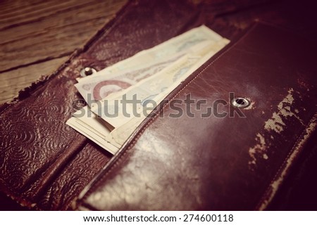 Old purse with soviet banknotes closeup on wood background