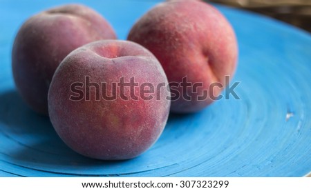 Juicy peaches on a bright blue plate with linen napkin