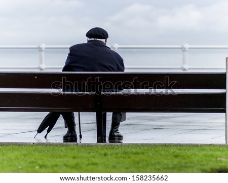Old man sitting in front of the sea