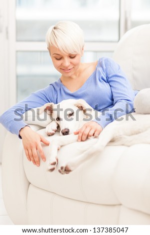 photo of woman sitting with young dog on the sofa