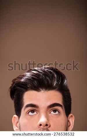 Closeup of half head of man with great hairstyle over brown background