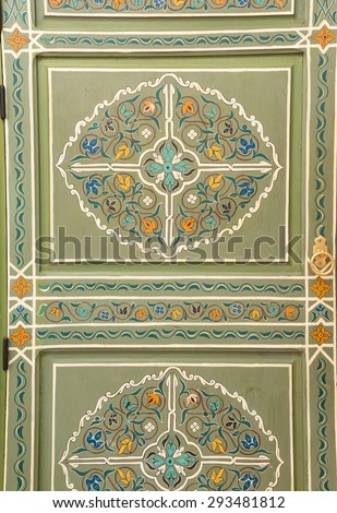 Close up traditional Moroccan style door in green with detailed handmade wood