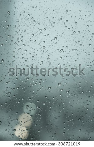Raindrops over the window with blurred background in vintage green sad tone