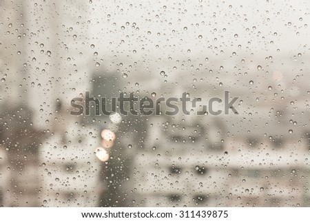 Raindrops over the window with blurred background in vintage sad tone