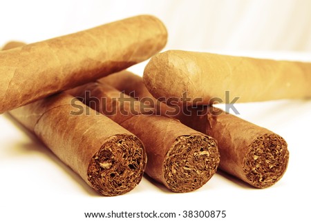 Stock image of Closeup of Five Cuban Cigars over light background. Sepia toned image.