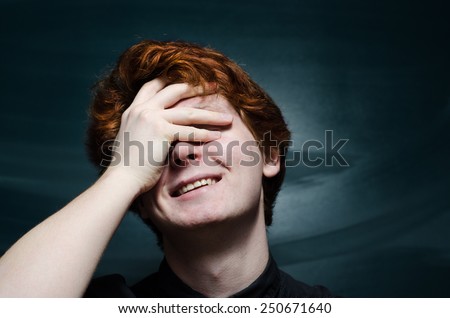 curly red head young man smiling face palm