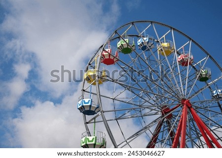 Similar – Image, Stock Photo A ferris wheel with red cabins beetween two bushes