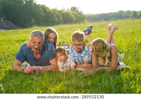 Large family on a green meadow. Family on a picnic.