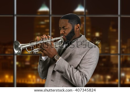 Black man plays the trumpet. Jazz trumpeter on night background. Composer's outstanding trumpet solo. Musician and instrument are one. Stock fotó © 