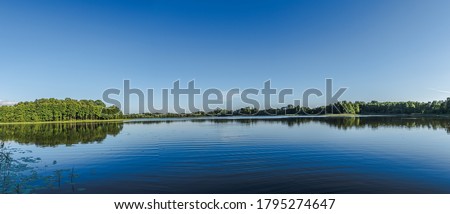 Similar – Foto Bild Kleiner Fluss in einem lettischen Wald, aufgenommen von einer Brücke. Das Wasser ist mit Wasserpflanzen bewachsen, viele Grüntöne und einige Gelbtöne. Frühherbst Landschaft, bewölkten grauen Himmel