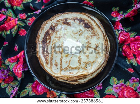 pancakes on the plate in the background of the Russian scarf,top view