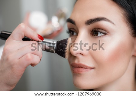 Image, Stock Photo Professional visagiste applying powder on model face