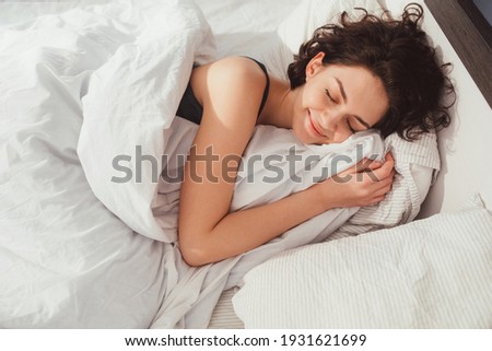 Woman sleeping. High angle view of beautiful young woman lying in bed and keeping eyes closed while covered with blanket. Stock photo Stock foto © 