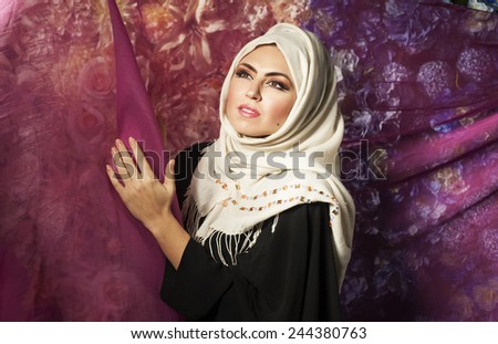 young mysterious Arabian girl dreaming in the flowers . portrait of a young Arab girl in a white scarf and burqa