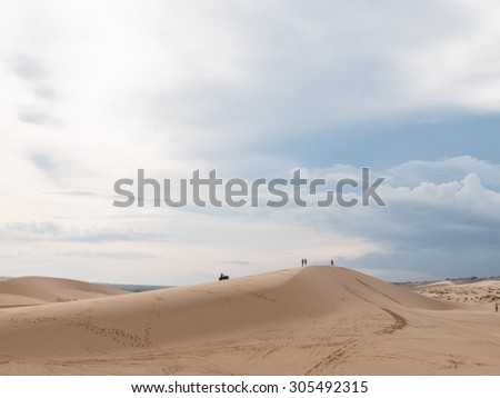 People talking together on top of white sand dunes desert Mui ne, Vietnam