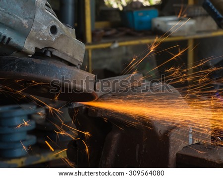 Grinding machine hand spinning with fire close up