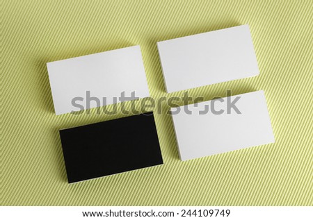 Black and white business cards on a green background. Mock-up for branding identity. Top view.