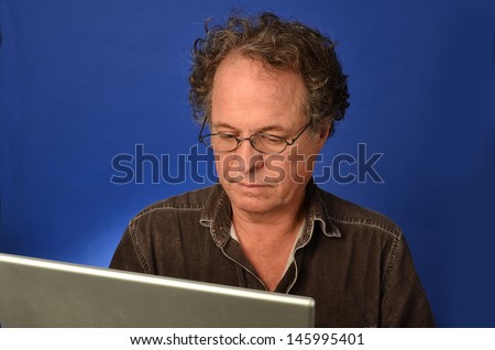 Senior man with expression looking at his computer/Older Man on Computer/Man is looking at his computer for emails and internet