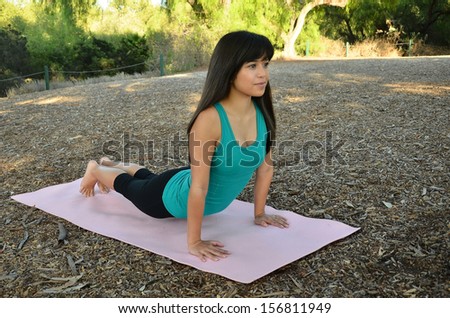 Young Asian woman doing her yoga/Outdoor Yoga/Young woman performs her postures in a park environment.
