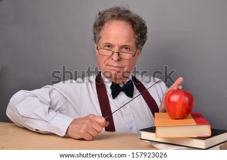 Mature man with books acting as a teacher/Mature Teacher/Man is a mature teacher character