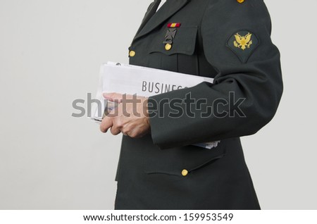 Veteran holding newspaper with business section/Veteran Looking for Work/Veteran in an army uniform holding business pages