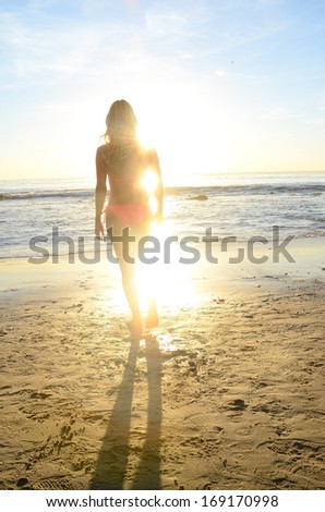 Beautiful woman in bikini during sunset/Bikini Sunset.Woman on a beach in a bikini during sunset