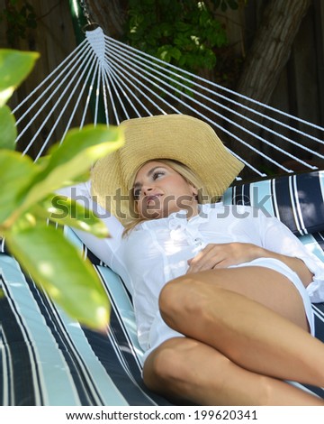 Woman on a enjoying her rest on a hammock/Woman on hammock/Beautiful woman resting on a hammock on a summer day