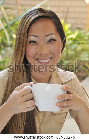 Woman outdoor with hot beverage/Asian woman with Hot Beverage/ Asian woman enjoying hot beverage out doors.