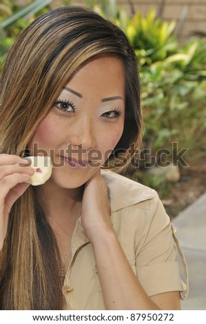 Woman enjoying food outdoors/Asian Woman Outdoor Dining/Asian outdoor with scone in hand