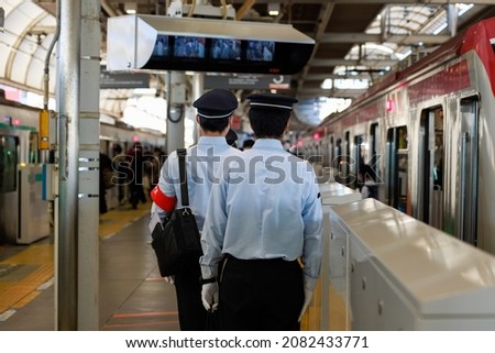 An apprentice conductor with a red armband to check before boarding on the platform of the station ストックフォト © 