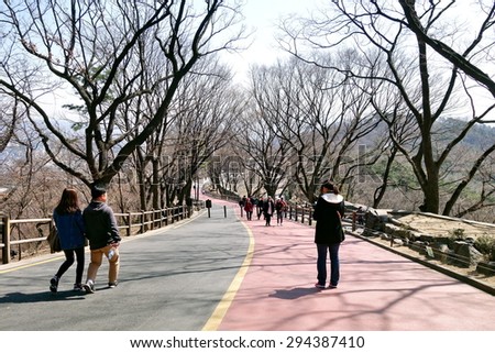 SEOUL, SOUTH KOREA - 25  MARCH , 2015: People walking along lane in Namsan park . This park is considered Seoul\'s principal park and on average welcomes 23,000 visitors every day.