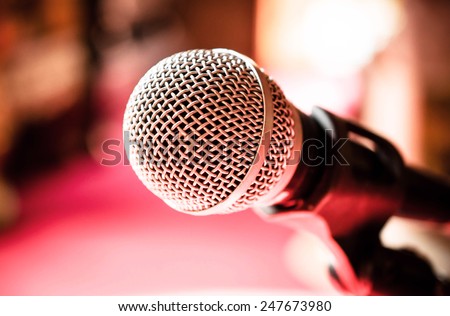 Close up of microphone in karaoke room or conference room / Microphone in karaoke room or conference room/ Close up of microphone in front of pink background (microphone, karaoke, music )