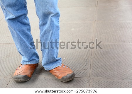 two legs of man wear jean and leather shoes