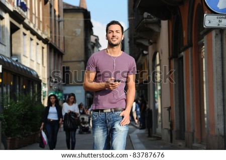 happy guy while talking on the phone to the streets of his city