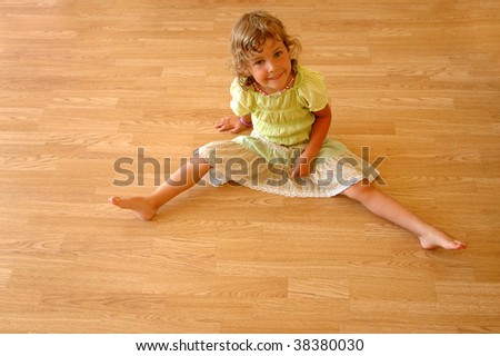 Child sits on wooden floor