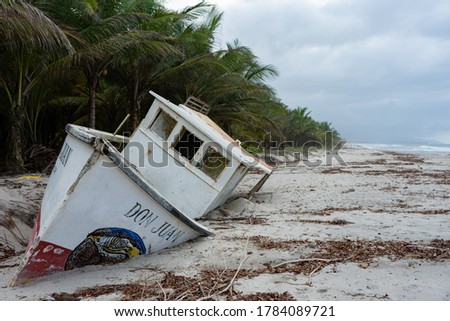 Wrecked boat on a beach in the Caribbean Sea in Colombia