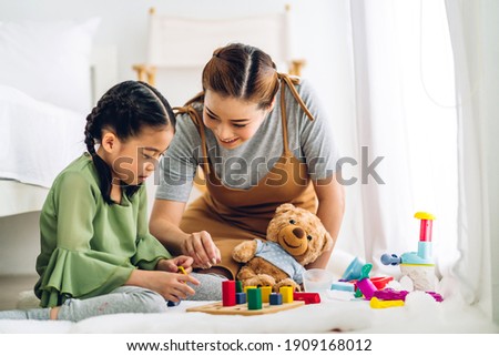 Portrait of enjoy happy love asian family mother and little asian girl smiling playing with toy build wooden blocks board game in moments good time at home