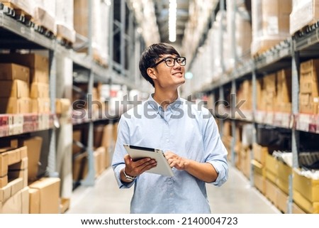 Portrait of smiling asian engineer foreman in helmets man order details checking goods and supplies on shelves with goods background in warehouse.logistic and business export Stock fotó © 