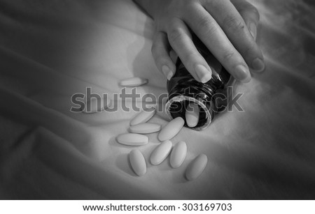 Hand of a person to committed suicide with sleeping tablets -  black&white, concept