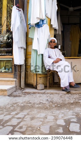 Aswan, Egypt - December 2005: A tailor seated outside his laboratory in the main traditional market of the town center