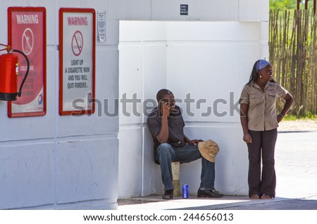 Owamboland, Namibia - December 11 2009; Local people in the shadow of a gas station in the Etosha National Park