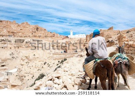Chennini, Tunisia - April15 2008: A local man on a donkey going to the ancient berber village