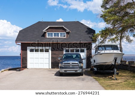 Roberval, Canada - May 10 2014: A  garage with car and boat on the St Jean lakeside