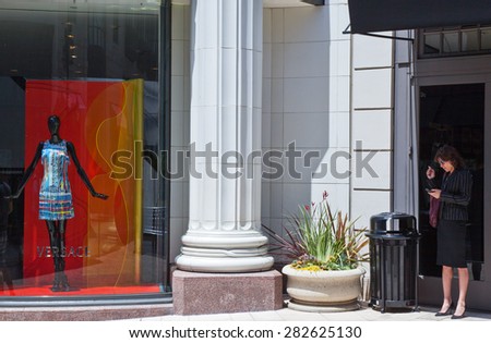 Los Angeles, U.S.A. - May 31 2011: A lady on the phone in front of a fashion store in Rodeo Drive