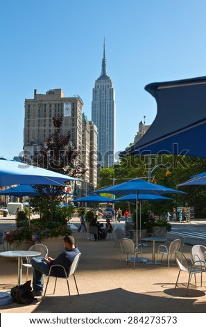 New York, U.S.A - July 8 2009: Manhattan,people in an open air bar with the Empire State Building in the background