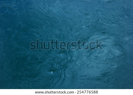 Deep dark water surface with few small whirlpools